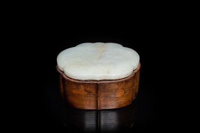 Een Chinese houten dekseldoos met een 'ruyi' plaquette in witte jade, 18/19e eeuw