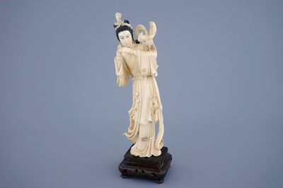 Een Chinese ivoren Guanyin met een vogel op houten sokkel, 19e eeuw