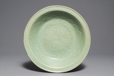 Een Chinese Longquan celadon schotel met onderglazuur pioenrozendecor, Ming