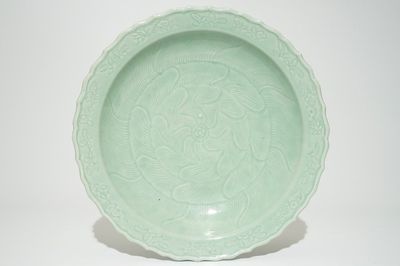 Een Chinese monochrome celadon schotel met floraal onderglazuur decor, Qianlong