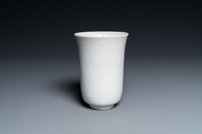 Een Chinese monochrome witte beker met anhua decor van pioenslingers, Xuande merk, Kangxi