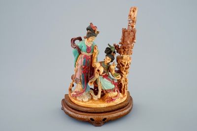 Een Chinese polychrome ivoren groep op houten sokkel, 19e eeuw