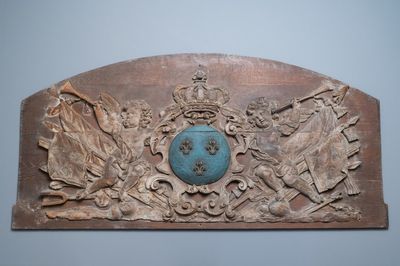 Een groot deels gepolychromeerd eikenhouten paneel met putti en trofeeën rond het koninklijk wapen van Frankrijk, 18e eeuw