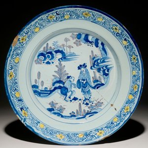 Een grote Delftse chinoiserie schotel in blauw met mangaan met deels gele buitenrand, 2e helft 17e eeuw — foto 1