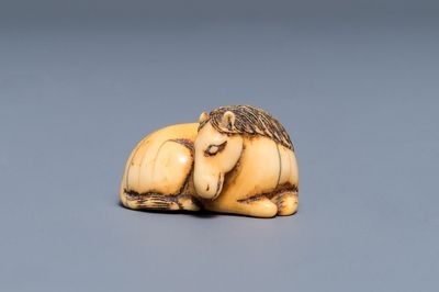 Een Japanse ivoren netsuke in de vorm van een liggend paard, Edo, 18/19e eeuw