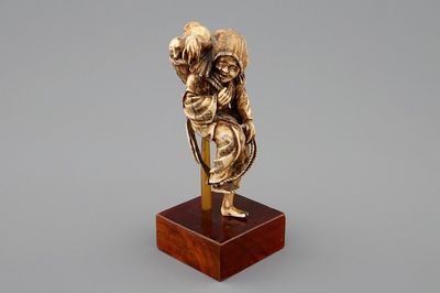 Een Japanse ivoren okimono van een dame met honden, Meiji, 19e eeuw