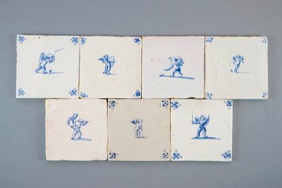 Een leuke set van 7 blauw-witte Delftse tegels met amortjes, 17/18e eeuw