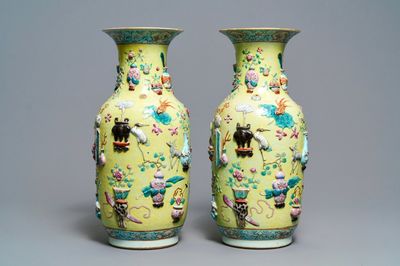 Een paar Chinese famille rose vazen met reliëfdecor op gele fondkleur, 19e eeuw