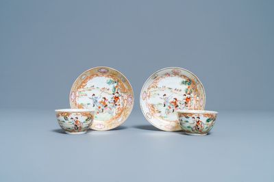 Een paar Chinese vergulde famille rose koppen en schotels met een jachtdecor, Qianlong