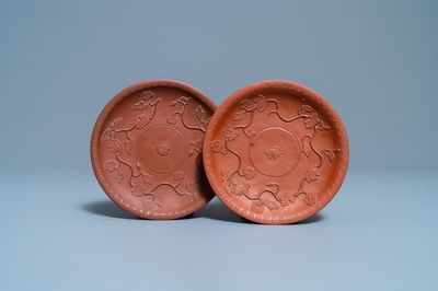 Een paar Chinese Yixing steengoed schotels met reliëfdecor, Kangxi