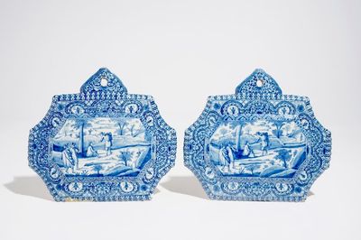 Een paar fijne blauwwitte Delftse plaquettes met reizigers in een landschap, 18e eeuw