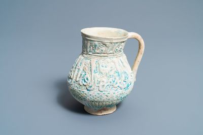 Een Perzische turquoise kan met kalligrafisch reliëfdecor, Kashan, 13/14e eeuw