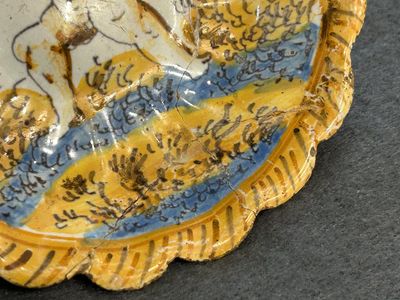 Een polychroom majolica schoteltje met een vechtende putto, atelier Verstraeten, Haarlem, 17e eeuw — foto 4