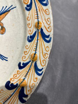 Een uitzonderlijke polychrome majolica schotel met een vliegende putto boven een hek, wellicht Haarlem, 1e helft 17e eeuw — foto 1