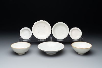 Four Chinese white-glazed saucers and three bowls, Yuan/Ming