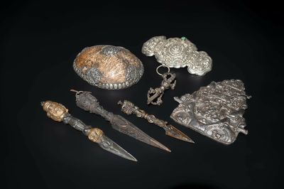 Four Tibetan bronze and wooden phurbas, a 'kapala' or skull-bowl and two silver ornaments, 19th C.