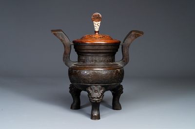 Important brûle-parfum tripod en bronze à décor de taotie au couvercle en bois, Chine, Ming