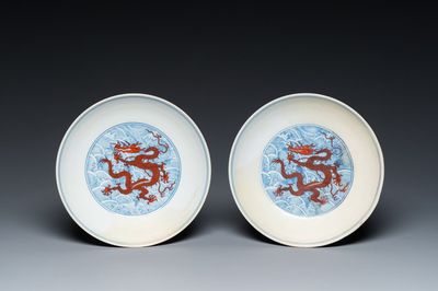 Paire de coupes en porcelaine de Chine à décor de dragons en rouge de fer sur fond de vagues en bleu et blanc, marque et époque de Qianlong