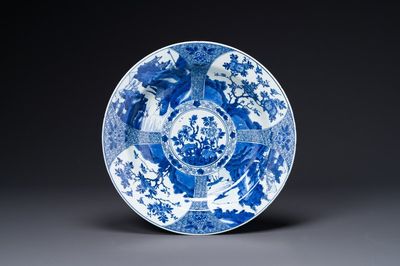 Plat en porcelaine de Chine en bleu et blanc à décor de panneaux paysagers et floraux, Kangxi