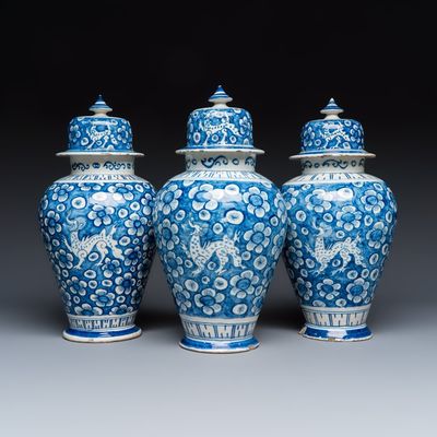 Three blue and white Dutch Delft vases and covers with dragons on a flowery ground, 18th C.
