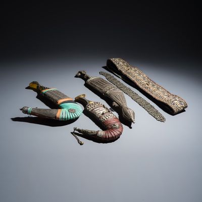 Three Yemeni jambiya-style daggers with metal mounts and two belts, 19/20th C.