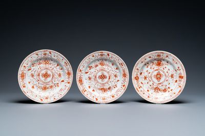 Trois assiettes en porcelaine de Chine en rouge de fer et doré à décor floral, Kangxi