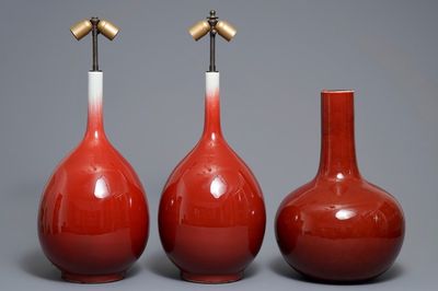 Trois vases de forme bouteille en porcelaine de Chine sang de boeuf monochrome, 20ème