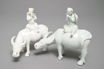 Twee Chinese blanc de Chine modellen van fluitspelers op buffels, 18/19e eeuw