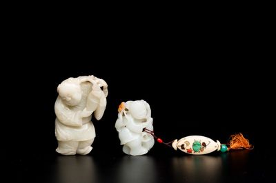 Twee Chinese witte en celadon jade sculpturen van staande jongens, Qing