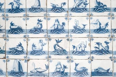 Un ensemble de 67 carreaux en faïence de Delft bleu et blanc aux monstres marins et bateaux, 18ème