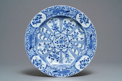 Un grand plat en porcelaine de Chine bleu et blanc à bordure aux paons, Kangxi