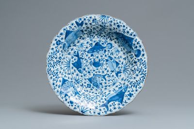 Un grand plat godronné en porcelaine de Chine en bleu et blanc à décor de poissons, Chine, Kangxi