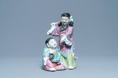 Un groupe en porcelaine de Chine famille rose figurant deux garçons avec une chauve-souris, marque en creux, République