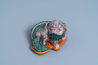 Un groupe en porcelaine de Chine figurant un lion bouddhiste et son lionceau sur socle en bois, 19ème