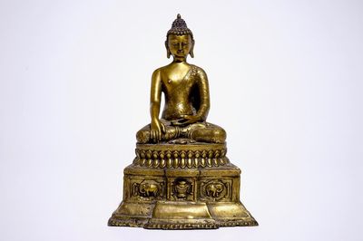 Un modèle d'un Bouddha assis sur un trone en bronze doré, Nepal ou Tibet, 19/20ème