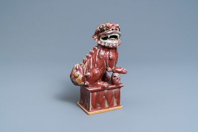 Un modèle d'un lion bouddhiste en porcelaine de Chine sang de boeuf monochrome, 19ème