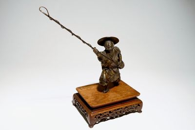 Un modèle d'un pêcheur en bronze sur socle en bois, Meiji, signé