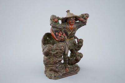 Un okimono en terre cuite polychrome figurant un marchand de fruits et singes, Japon, Edo/Meiji, 18/19ème