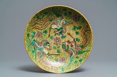 Un plat en biscuit émaillé vert, jaune et aubergine à décor de phénix, marque He He Jia Chan, époque Transition