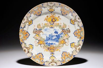 Un plat en faïence de Delft polychrome au médaillon d'un paysage fluvial, 18ème