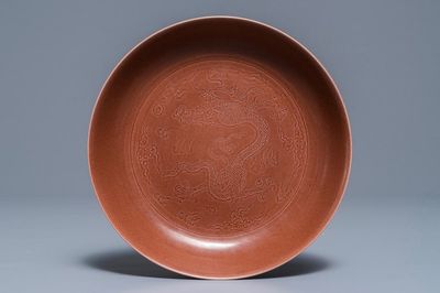 Un plat en porcelaine de Chine aubergine monochrome à décor incisé d'un dragon, marque et époque de Jiaqing
