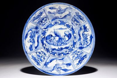 Un plat en porcelaine de Chine bleu et blanc à décor de figures dans un paysage, époque Transition