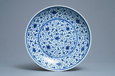 Un plat en porcelaine de Chine bleu et blanc à décor de rinceaux floraux de style Ming, Qianlong