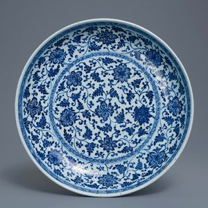 Un plat en porcelaine de Chine bleu et blanc à décor de rinceaux floraux de style Ming, Qianlong — photo 1