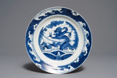 Un plat en porcelaine de Chine bleu et blanc à décor d'un dragon et une carpe, Kangxi
