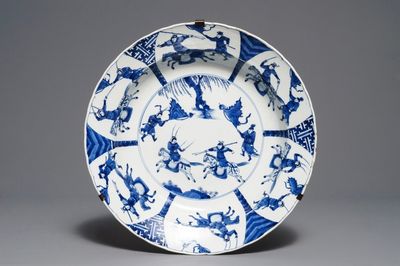 Un plat en porcelaine de Chine bleu et blanc à décor d'une bataille, marque de Chenghua, Kangxi