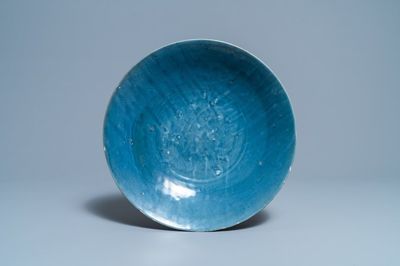 Un plat en porcelaine de Chine bleu monochrome à décor incisé d'une carpe, fours de Swatow, Ming