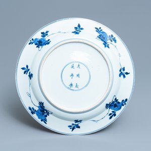 Un plat en porcelaine de Chine en bleu et blanc à décor de femmes autour d'une jardinière, Kangxi — photo 2