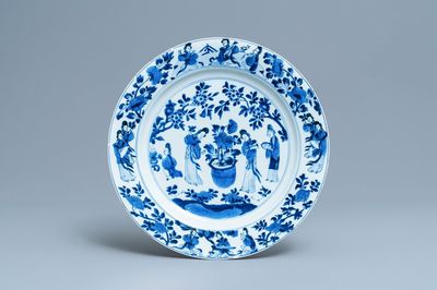 Un plat en porcelaine de Chine en bleu et blanc à décor de femmes autour d'une jardinière, Kangxi
