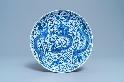 Un plat en porcelaine de Chine en bleu et blanc à décor d'un dragon, marque et époque de Kangxi